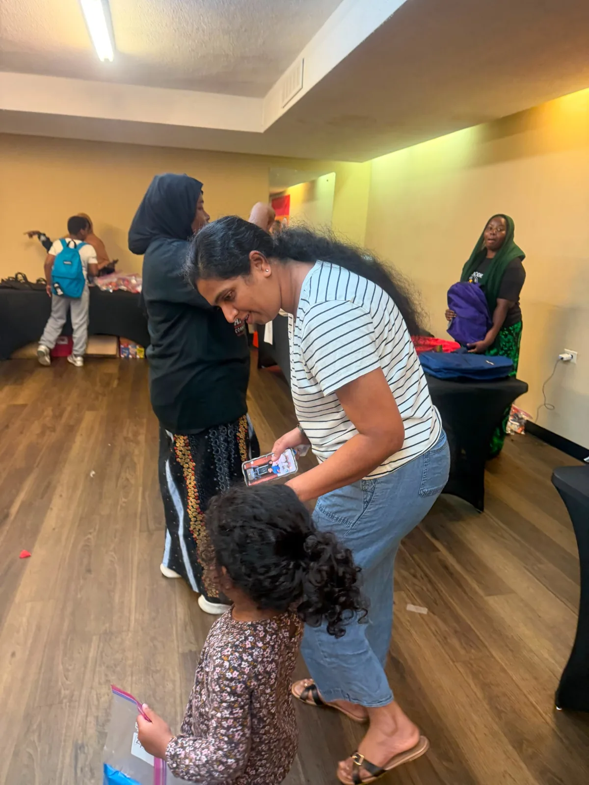 A parent and child leaving with backpacks and school supplies.