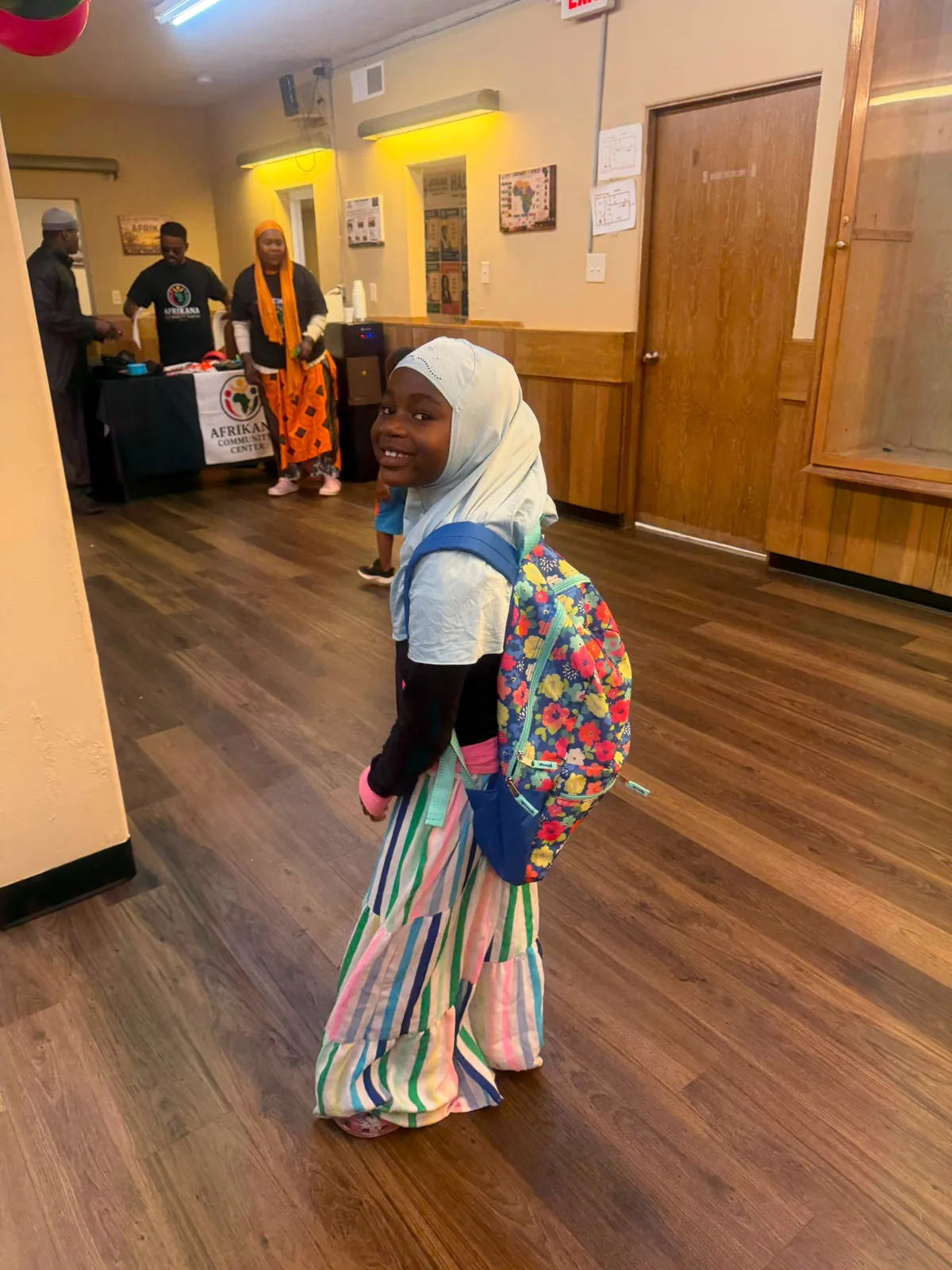 A student proudly wearing her new backpack after receiving Back-to-School support.