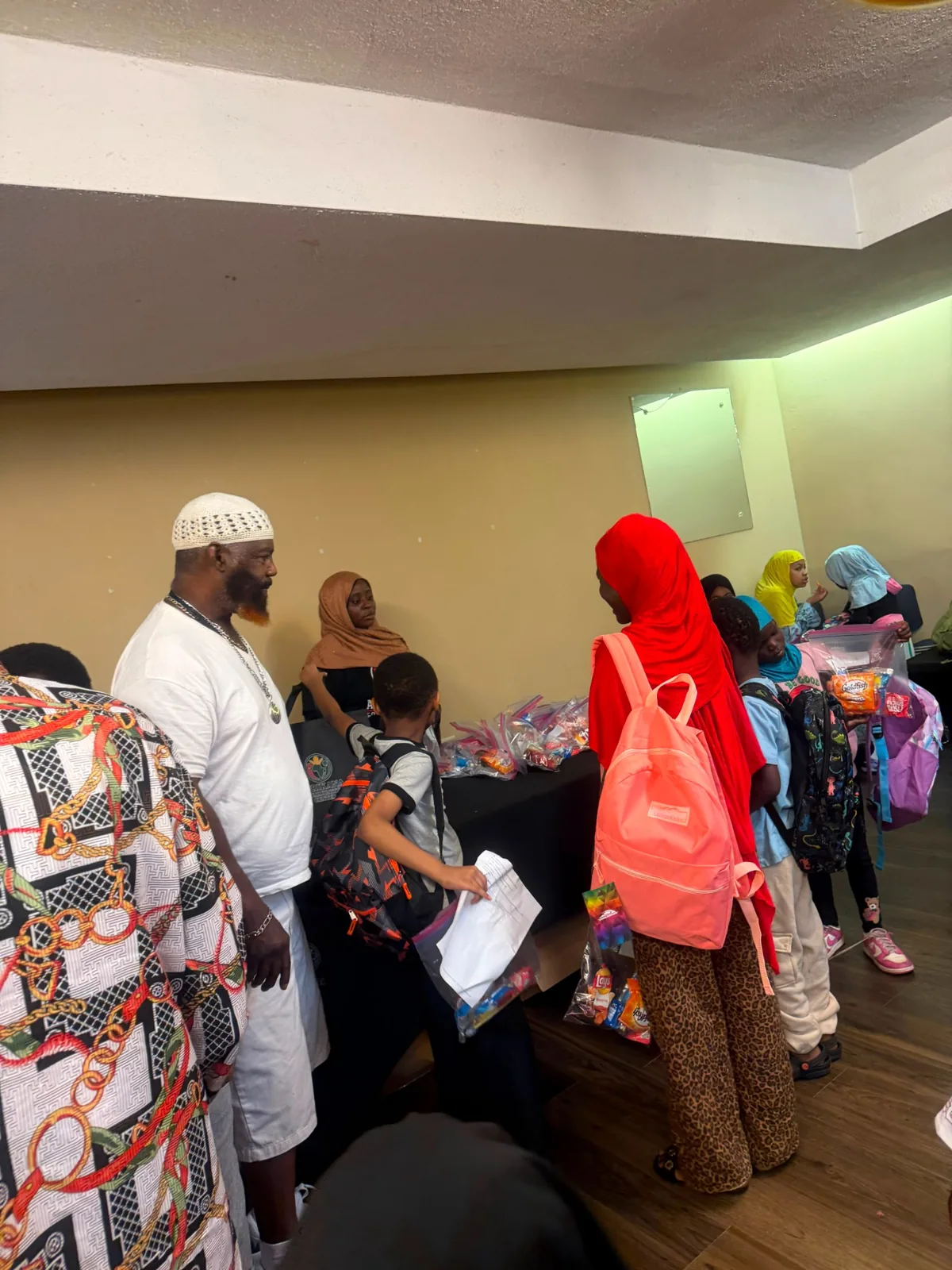 Families gathering at the distribution tables inside Afrikana Community Center.