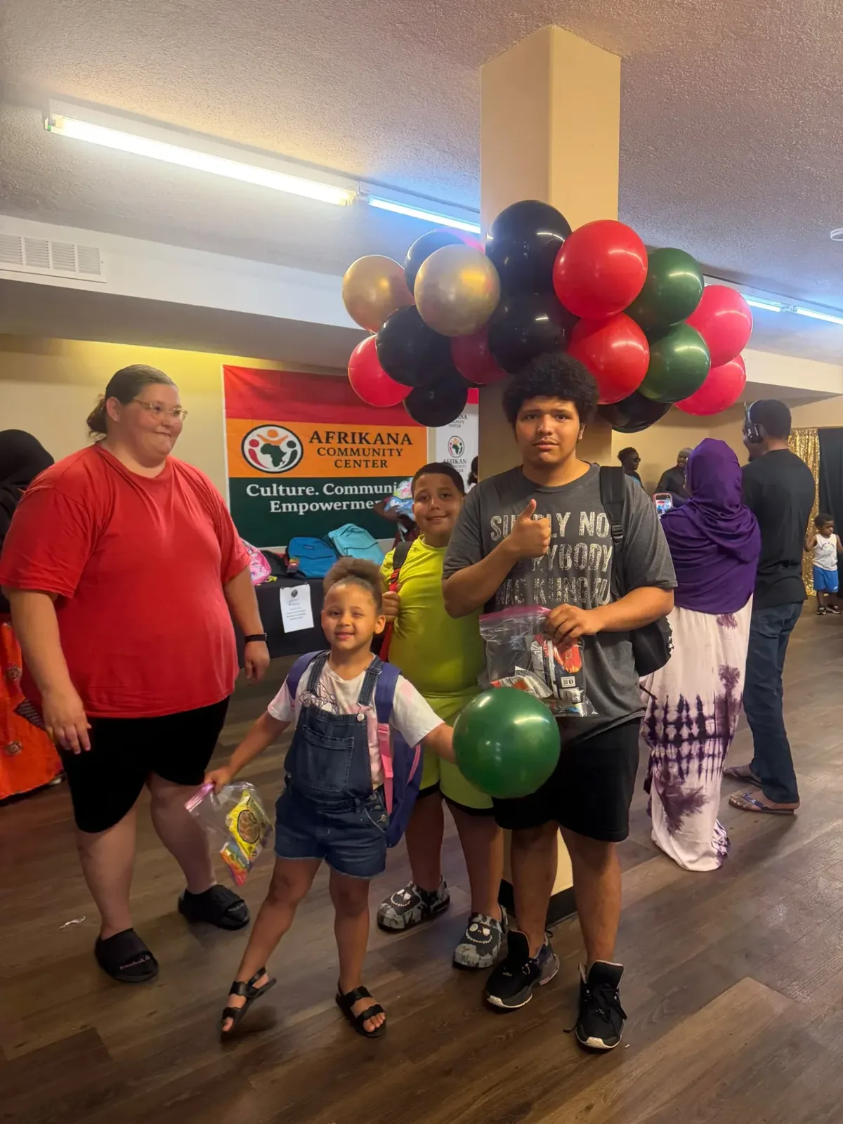 Family receiving backpacks at Afrikana Community Center's 2026 Back-to-School Giveaway