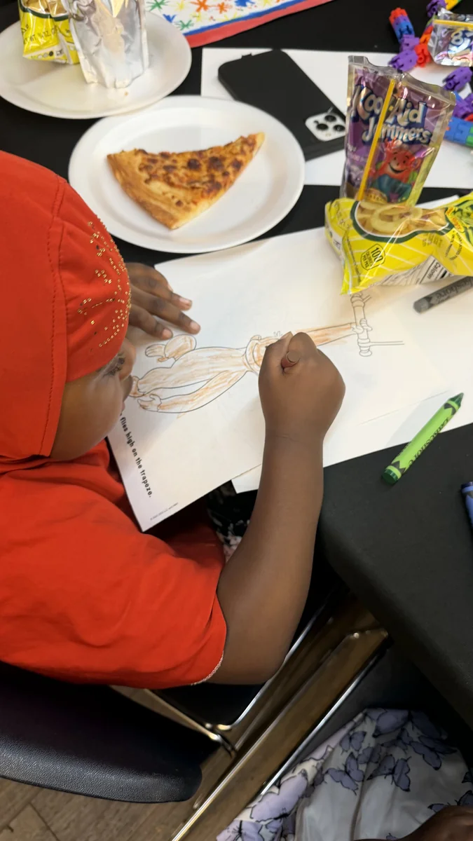 A child focused on coloring during an After-School Youth Program session.