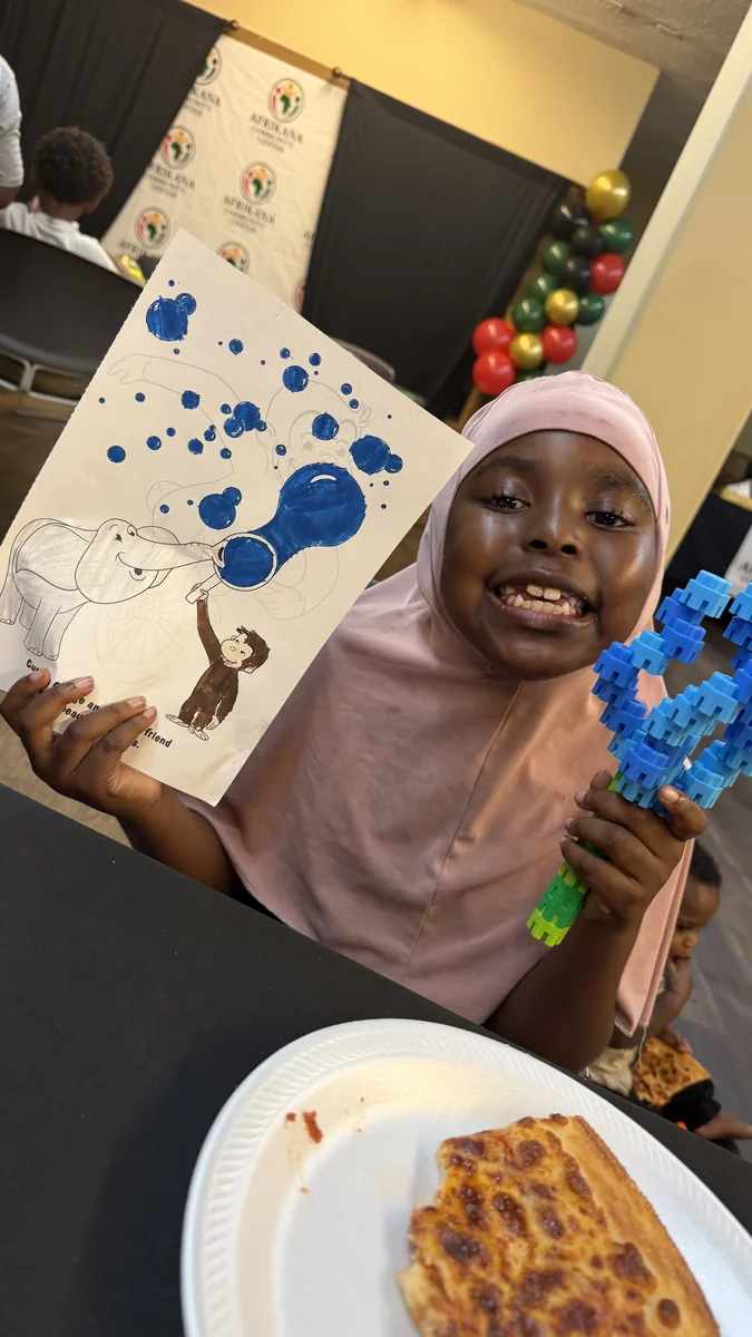 A young participant shares her painting and building-block creation.